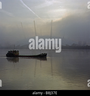 Completed structure of the Millennium Dome/O2 Arena in London looms indistinctly in the early morning river mist at Greenwich. Stock Photo
