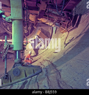 After excavating a rock face, a tunnel boring machine pulls itself forward using huge hydraulic rams braced against tunnel wall. Stock Photo