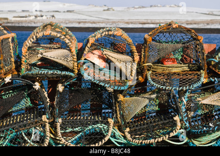 dh  CREELS UK Metal and rope Lobster crab pots stacked winter snow Stock Photo