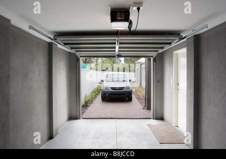 A car driving into a garage with an automatic garage door. Stock Photo