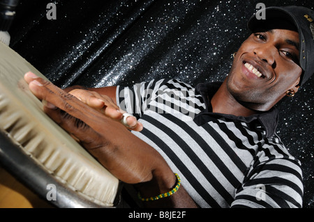 Portrait of young latino percusionist playing african drums Stock Photo