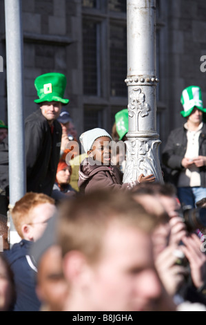 Onlookers enjoy the spectacle of the St Patricks Day Parade in sunshine in Dublin Ireland with a small boy in the centre Stock Photo