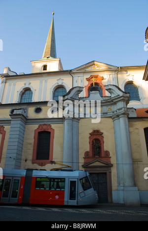 Tram passing Sv Tomas church in Mala Strana quarter of Prague Czech Republic Europe Stock Photo