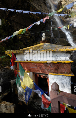 Water driven prayer wheel and prayer flags at the Paro Taktsang Goemba, monastery, know as the  Tigers Nest . Stock Photo