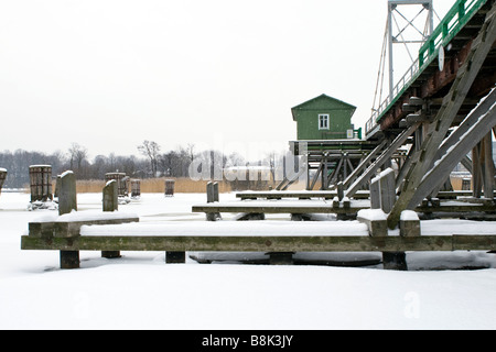 Frozen river bridge wooden piers construction view. Stock Photo