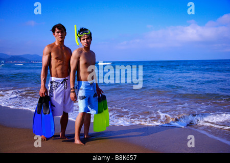 Two men holding the flippers wearing the swimming goggles and looking at the camera Stock Photo