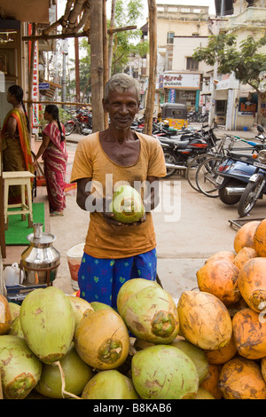 India Tamil Nadu Madurai man selling fresh young coconuts to drink Stock Photo
