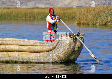 Uros Indian man in tortora reed boat with floating tortora reed island ...