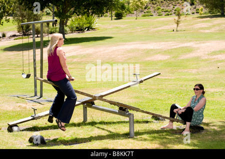 Women playing on swings in Hamilton gardens, New Zealand Stock Photo