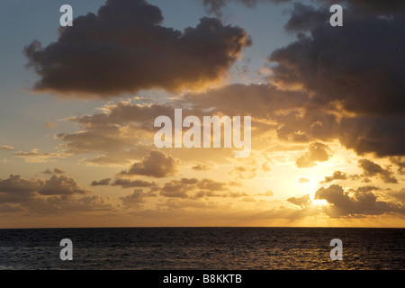 The sun rises over the Gulf of Mexico at sunrise on Ambergris Caye in Belize. Stock Photo