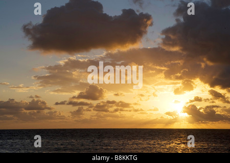 The sun rises over the Gulf of Mexico at sunrise on Ambergris Caye in Belize. Stock Photo