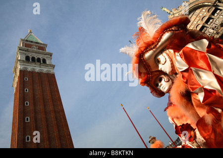 Venetian masks at Venice Carnival 2009, with St Mark's bell tower, Venice, Italy Stock Photo