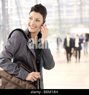 Portrait of happy young businesswoman calling on mobile phone smiling Stock Photo