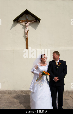 Newlyweds in front of the church of the Holy Cross in the castle complex of Banska Bystrica Stock Photo