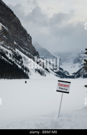 Danger Thin Ice sign on a frozen Lake Louise in Banff National Park, Alberta, Canada. Stock Photo