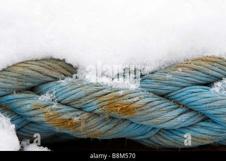Old stron blue towing cable covered with snow in winter time. Stock Photo