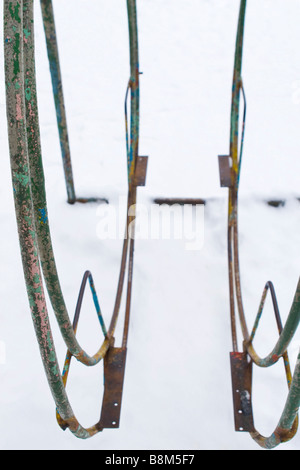 Splited in two parts big swings on winter playground. Stock Photo