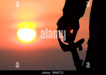 Sunset in Gettysburg National Park with a statue of Major General Gouverneur K. Warren in the foreground holding a sword. Stock Photo