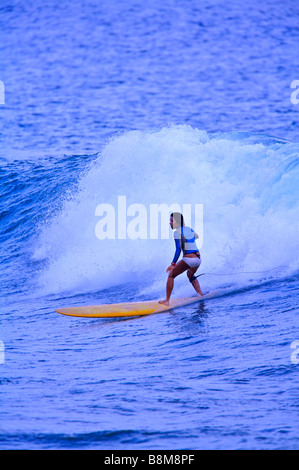 Young woman surfer breaking through wave skillfully Stock Photo