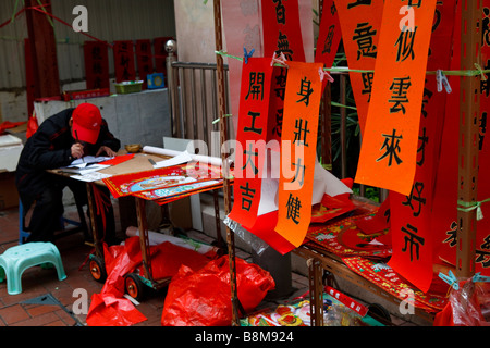 A calligrapher drafting up bans for the Lunar New Year in Sheung Wan, Hong Kong. Stock Photo