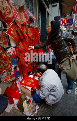 A calligrapher prepares lucky bans for the Lunar/Chinese New Year in Wanchai, Hong Kong. Stock Photo