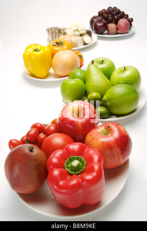 Different kinds of fruits and vegetables on the plates close up Stock Photo