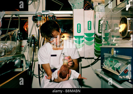 A nurse feeds a newborn baby in the premature baby unit of Whips Cross hospital Stock Photo