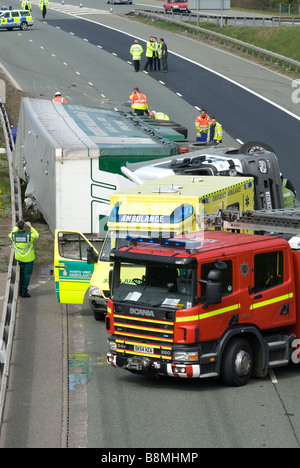 Crashed lorry on motorway with fire engine and ambulance Stock Photo