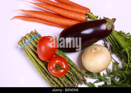 A Stock photo of a garden variety of fresh produce, including carrots, eggplant, tomato, onion and asparagus. Stock Photo