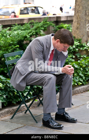 Businessman sitting outside talking on his cell phone Stock Photo