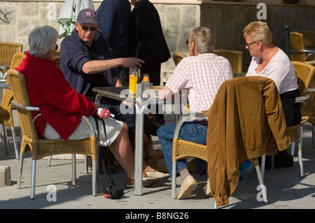 Two Couples People Friends Enjoying a Drink Drinking at an Outside Pavement Cafe Spain Stock Photo
