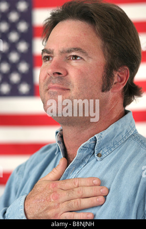 A handsome man pledging alliegance to the American flag Stock Photo