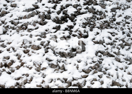 Small bravel pile background pattern covered with snow. Stock Photo
