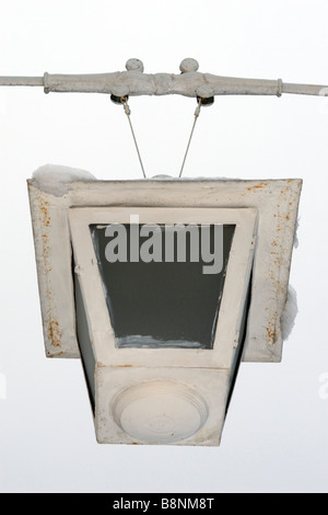 Classical forged hanging lantern in winter covered with snow. Stock Photo