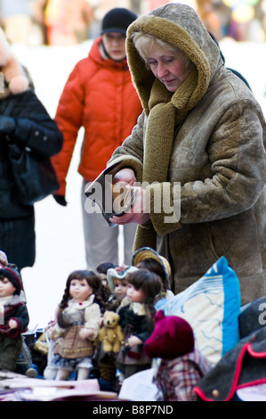 A woman buying hand-crafted doll at a winter fete (Russia) Stock Photo