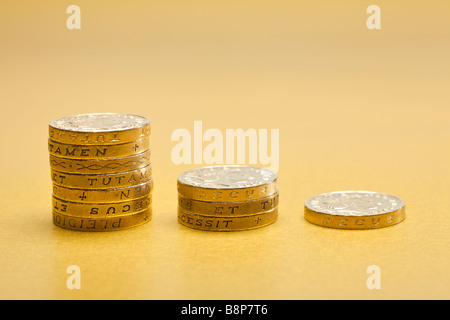 Decreasing stacks of £1 one pound coins sterling on gold background