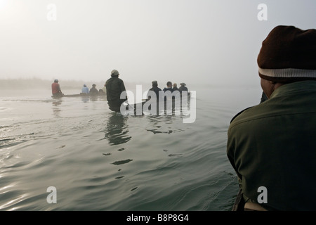 Tourist groups on morning canoe trip on Rapti river in Royal Chitwan National Park Nepal Stock Photo