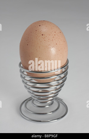 Whole egg in a modern chrome egg cup Stock Photo