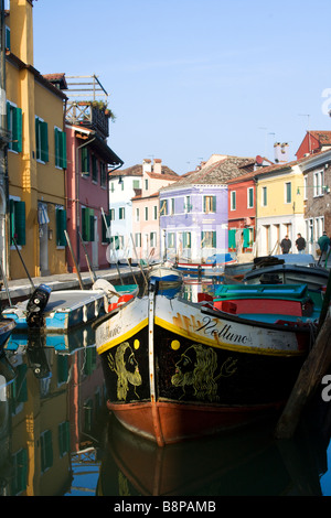 closeup of traditional boat and portrait view of canal and colorful houses in the island of Burano , Venice , Italy Stock Photo