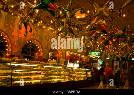 Mi Tierra Bakery baked goods counter with customers and display with overhead decor mexican pinatas San Antonio Texas tx landmark Stock Photo