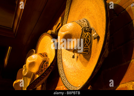 Mexican sombreros indoors hanging on wall in row Stock Photo
