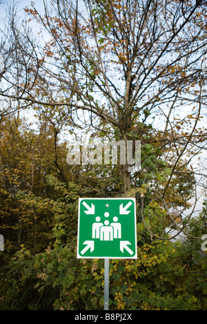 Emergency assembly sign in wooded area Stock Photo