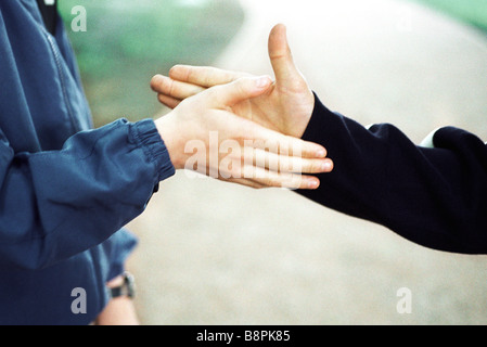 Boys reaching to shake hands, cropped view Stock Photo