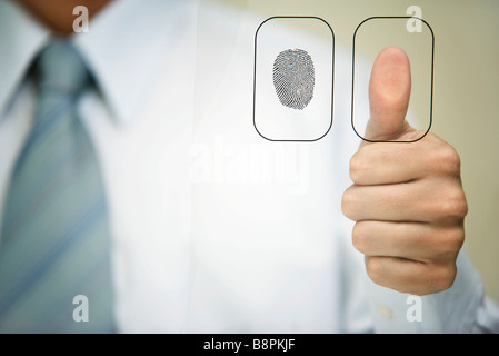 Man pressing thumb to fingerprint reader Stock Photo