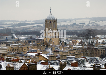 Old Tom the tower at Christchurch College Oxford University covered in snow with Hinksey Heights behind it Stock Photo