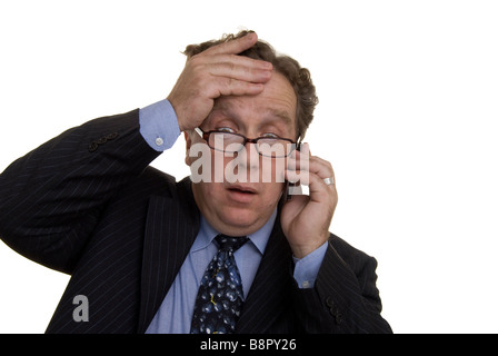 businessman gesticulating while talking on the phone looking shocked Stock Photo