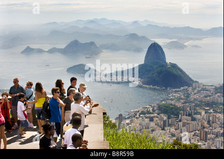TOURISTS VIEW RIO DE JANEIRO FROM CORCOVADO HILL, BELOW CHRIST THE REDEEMER STATUE LOOKING TOWARDS SUGARLOAF MOUNTAIN