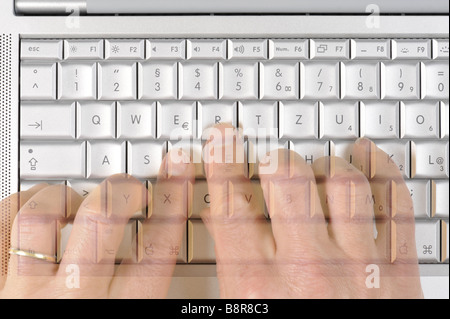 two hands typing on a Apple MacBook Pro keyboard Stock Photo