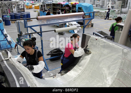 Workers next to a giant wind turbine blade at the factory VentoMoinho at Viana do Castelo, Portugal. Stock Photo