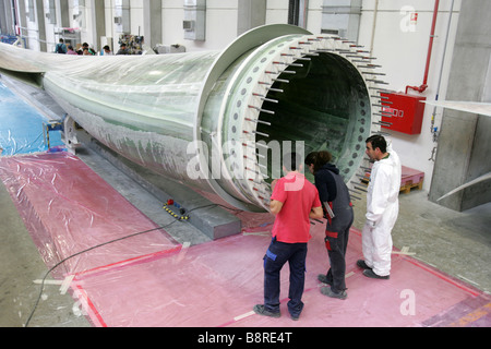 Workers next to a giant wind turbine blade at the factory VentoMoinho at Viana do Castelo, Portugal. Stock Photo